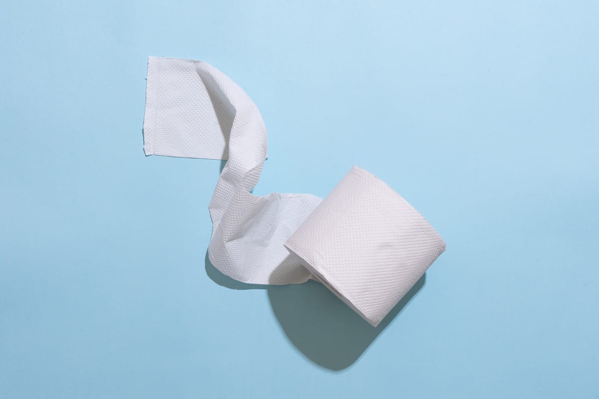 Unsplash, how to save money on toilet paper, roll of toilet paper on blue background