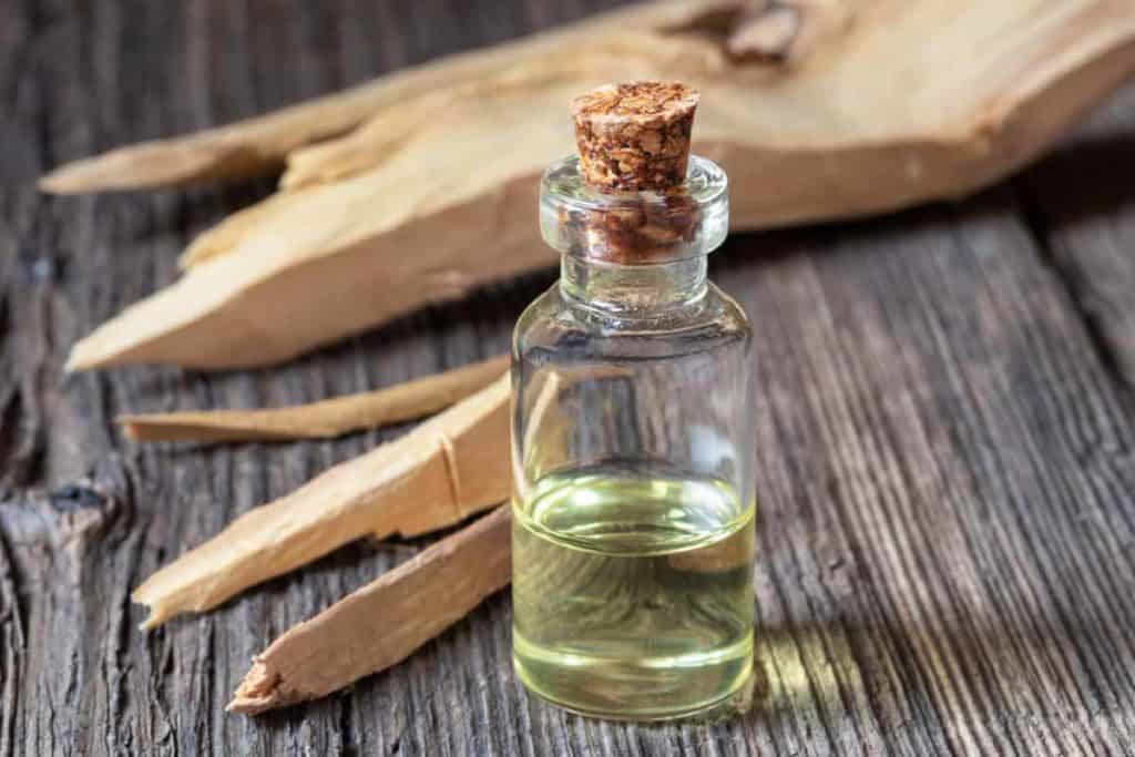 Sandalwood soap benefits, bottle of sandalwood essential oil with white sandalwood