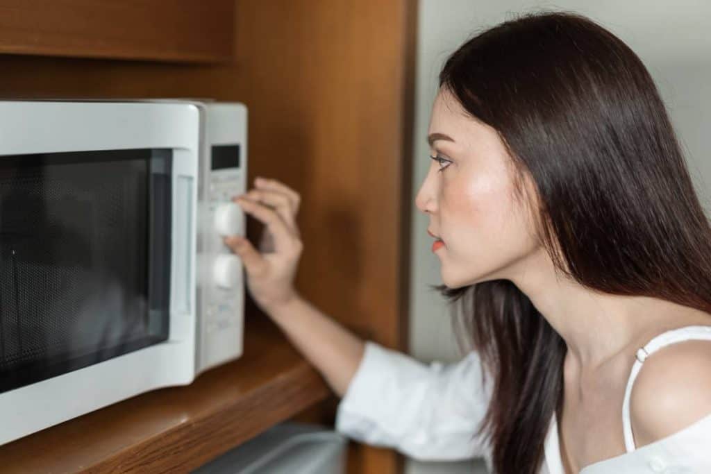 microwave safe symbol, woman cooking with a microwave in kitchen