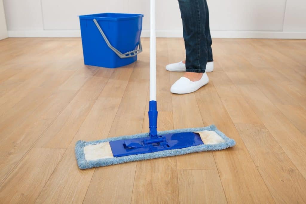 best way to clean LVP flooring, woman mopping floor